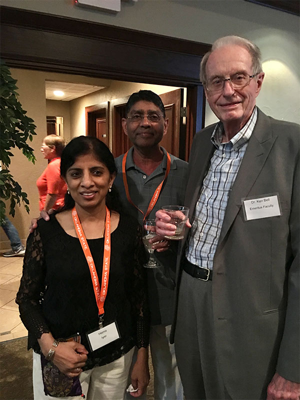 Three people stand together at a celebration.
