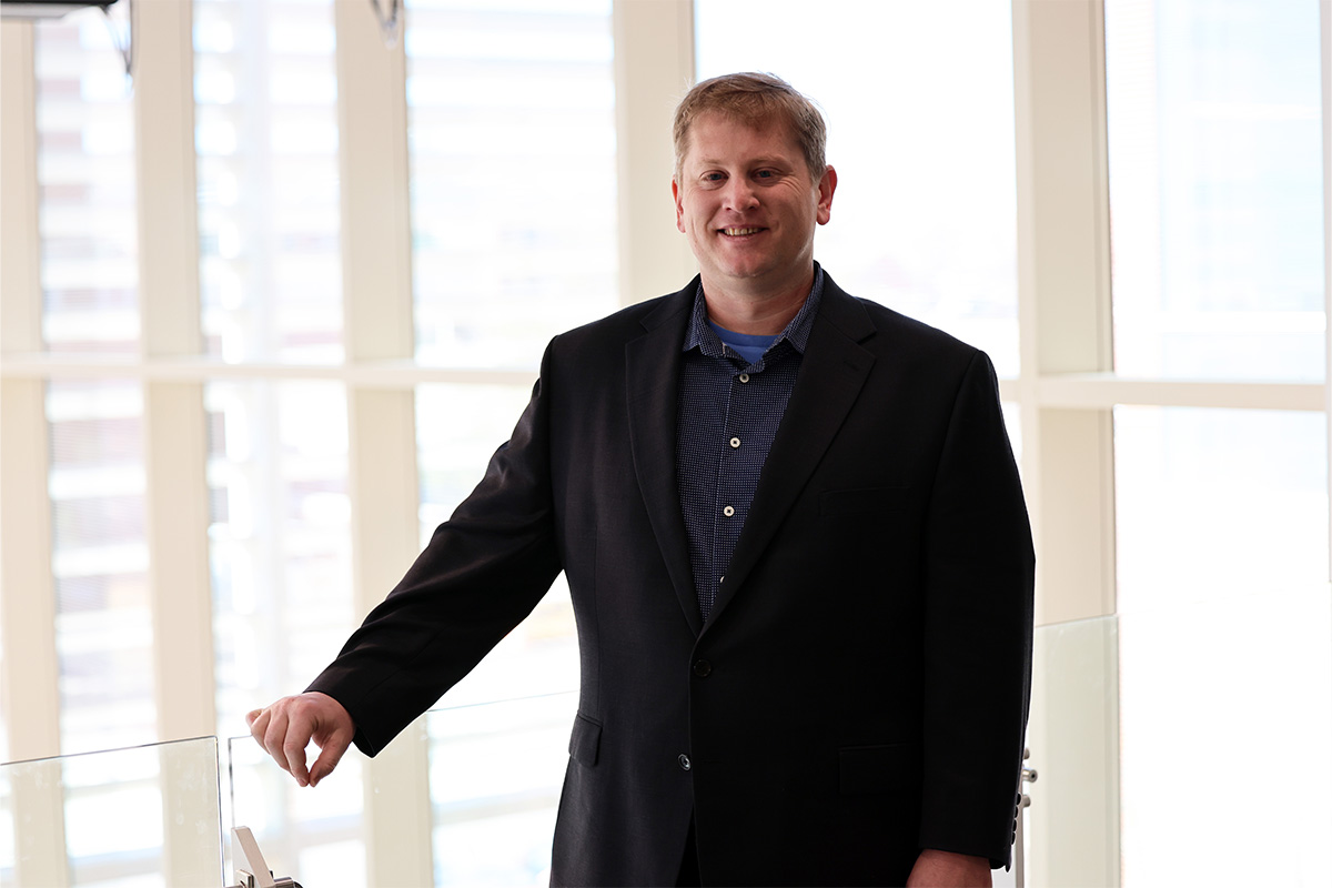 Dr. Mark Krzmarzick is photographed wearing a suit inside the ENDEAVOR Lab at Oklahoma State University.