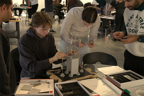 A group of Oklahoma State University architecture students work together on a Mola model kit. The kits are designed to simulate how real-world impacts such as earthquakes can impact the integrity of a structure.