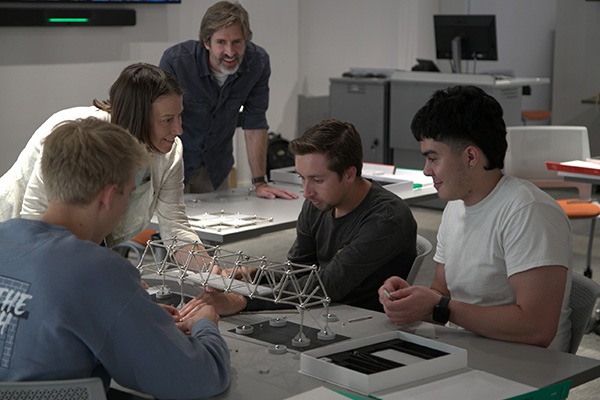 A group of Oklahoma State University architecture students work together on a Mola model kit. The kits are designed to simulate how real-world impacts such as earthquakes can impact the integrity of a structure.