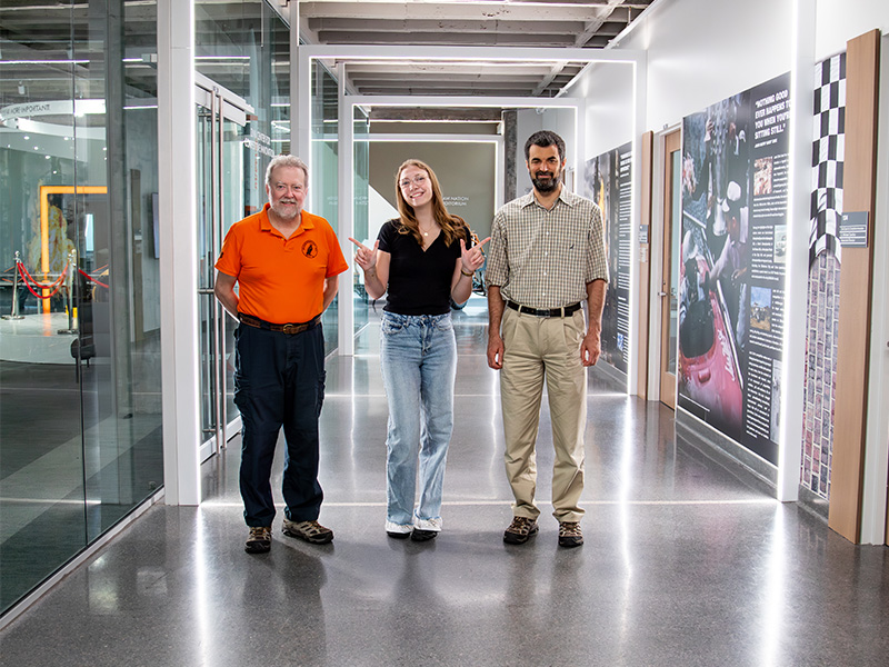 Sophie Hawkins in the hall of Engineering South with Mechanical and Aerospace Engineering faculty advisors
