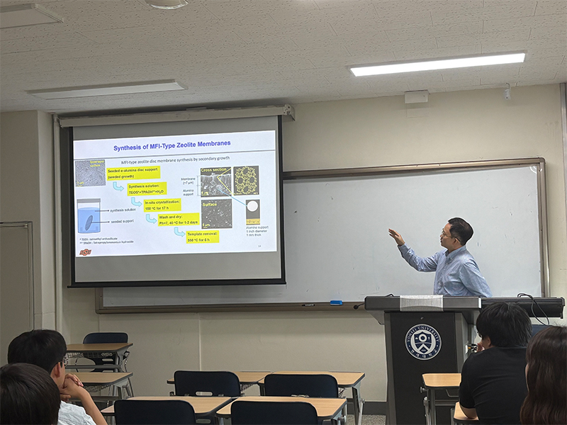 June 2025 Seminar, Yonsei University, Chemical & Biomolecular Engineering, Korea a student standing at a podium and presenting while pointing to a screen at his side. 