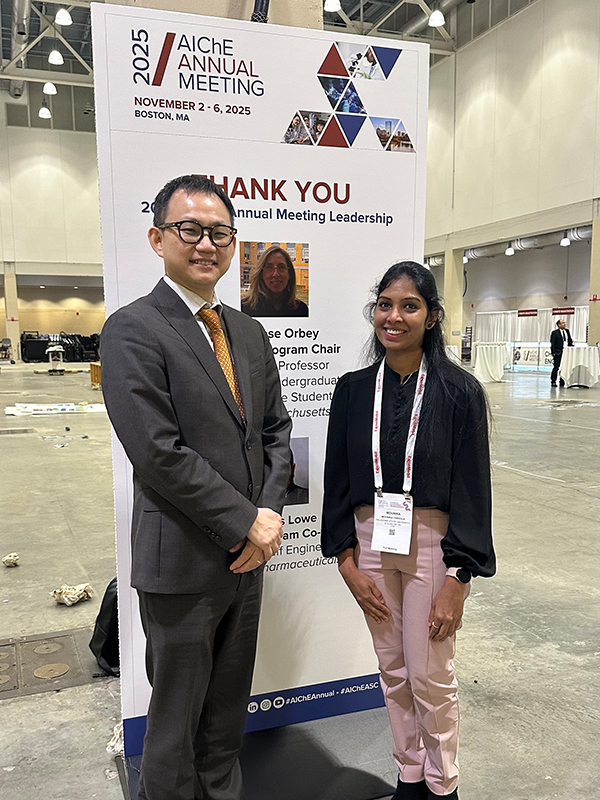 Dr. Kim and Mounika Chevula standing in front of a banner at the AIChE Meeting in Boston, MA