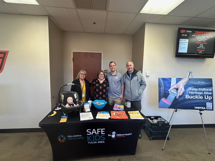 Oklahoma Highway Safety/SAFE Kids Tulsa Area/The Children's Hospital of St. Francis transportation safety booth with sign, flyers, and workshop participants Oklahoma Highway Safety/SAFE Kids Tulsa Area/The Children's Hospital of St. Francis transportation safety booth with sign, flyers, and workshop participants