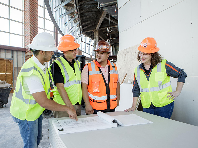 Rachel Mosier works with students at a construction site