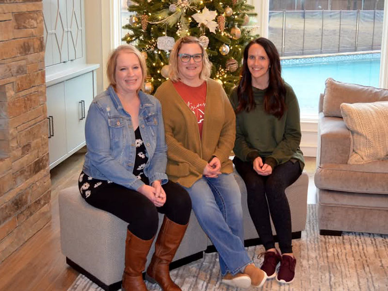 Three women sitting on a couch. Three women sitting on a couch.