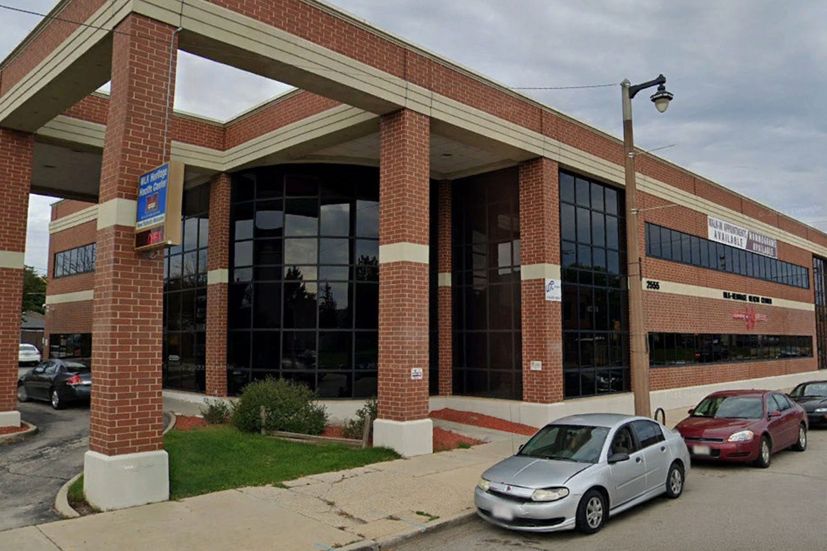 photo of a brown brick building with large brick columns in the front.