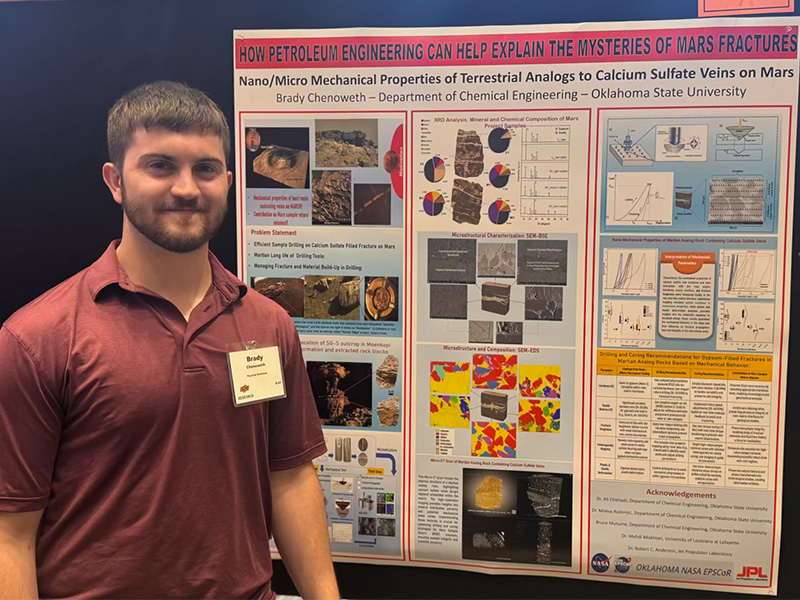 An undergraduate chemical engineering student with their research poster.