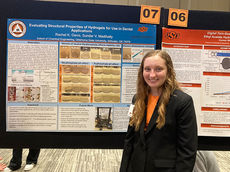 An undergraduate chemical engineering student with their research poster.