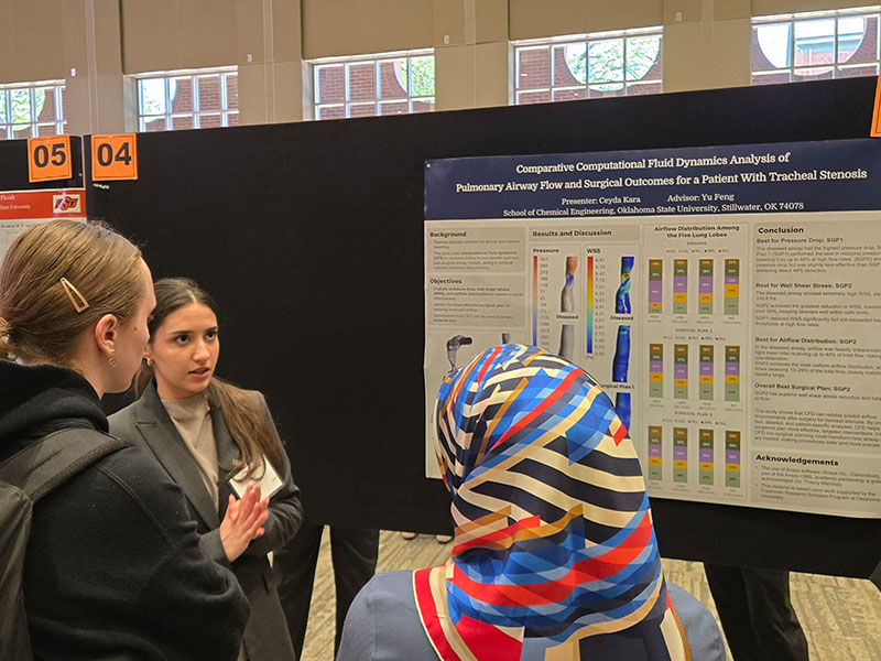 An undergraduate chemical engineering student with their research poster.