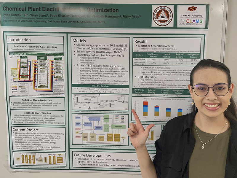 An undergraduate chemical engineering student with their research poster.