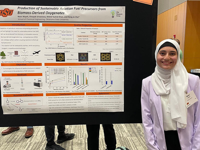 An undergraduate chemical engineering student with their research poster.