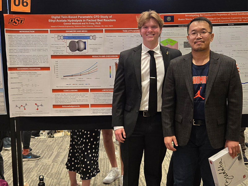An undergraduate chemical engineering student with their research poster.