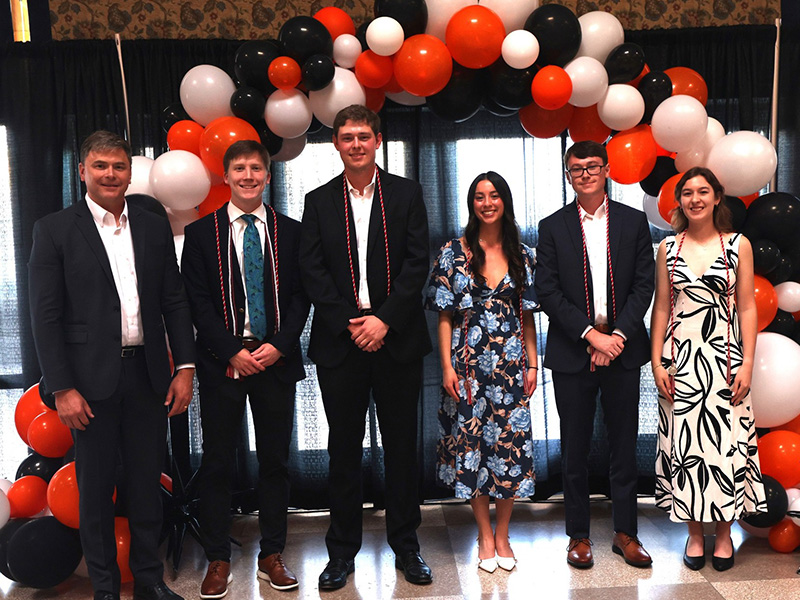 Students smile after receiving a chemical engineering award. 