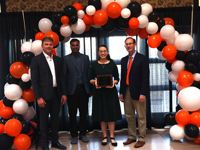 A student smiles after receiving a chemical engineering award. 