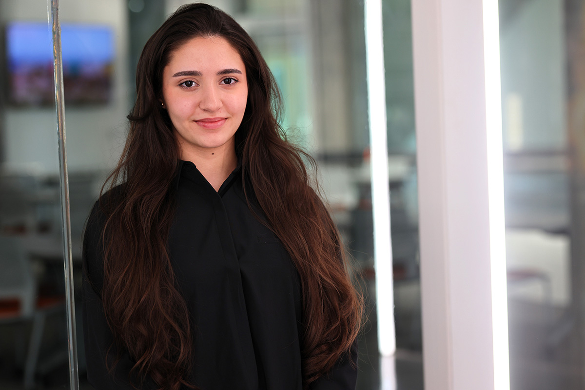 ceyda_header.jpg A woman dressed in a black blouse poses for a headshot with a modern, industrial background.