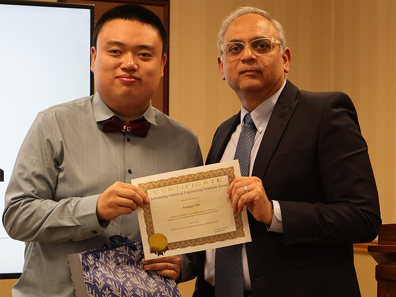 A student smiles after receiving a chemical engineering award. 