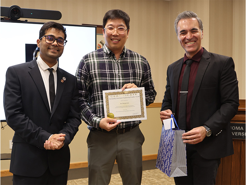 A man smiles after receiving an outstanding engineering faculty award.