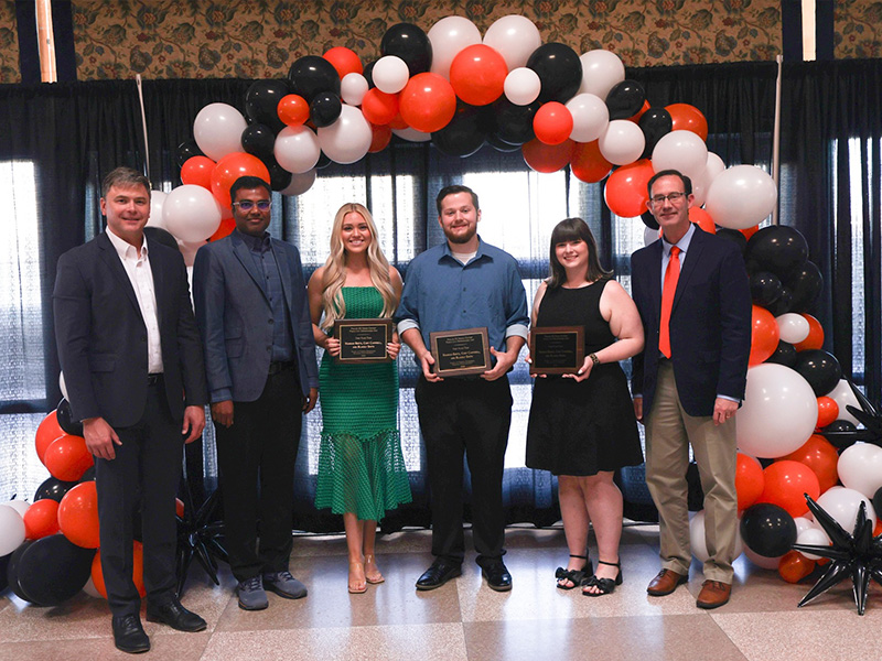A group of people smile with an award. 