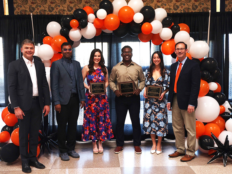 A group of students smile after receiving an award.
