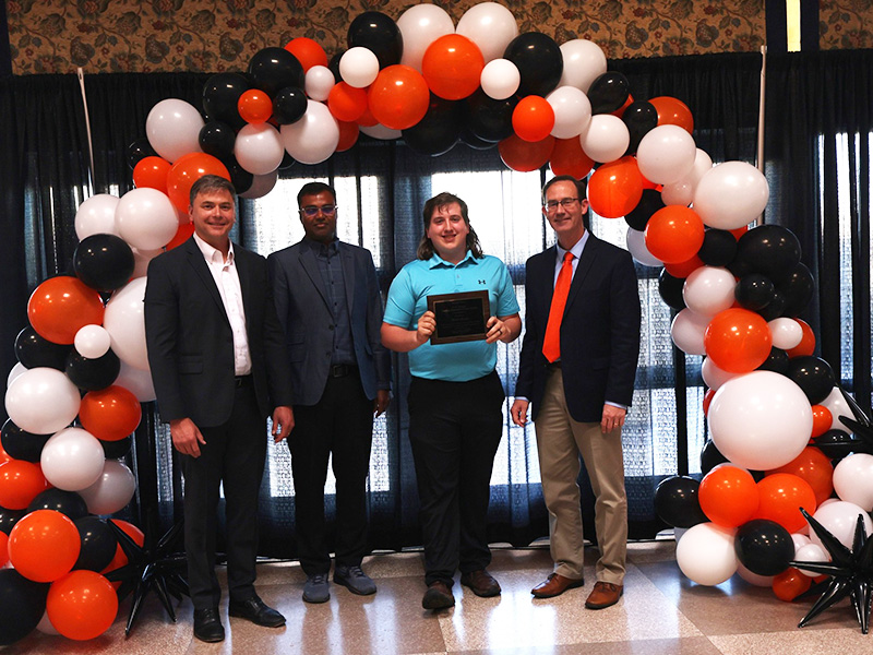 A student smiles after receiving a chemical engineering award. 