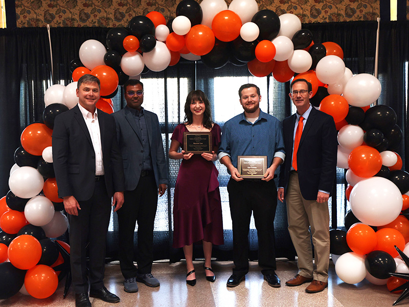 Students smile after receiving a chemical engineering award. 