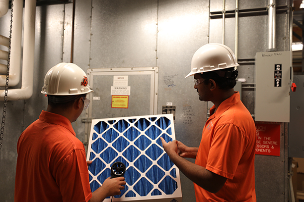Students examining an air filter 
