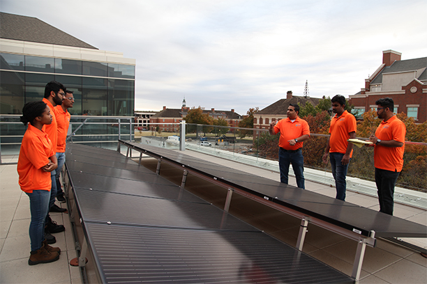 IAC students looking at solar panels