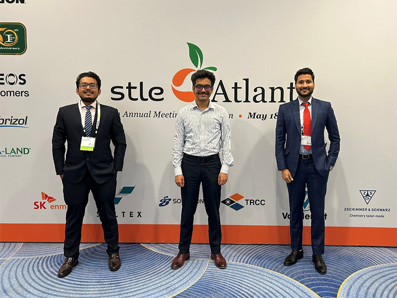 news-5-25-1.jpg three gentlemen in suits standing in front of a backdrop that states STLE Atlanta
