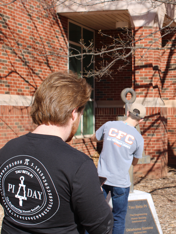 Tau Beta Pi students polishing their statue